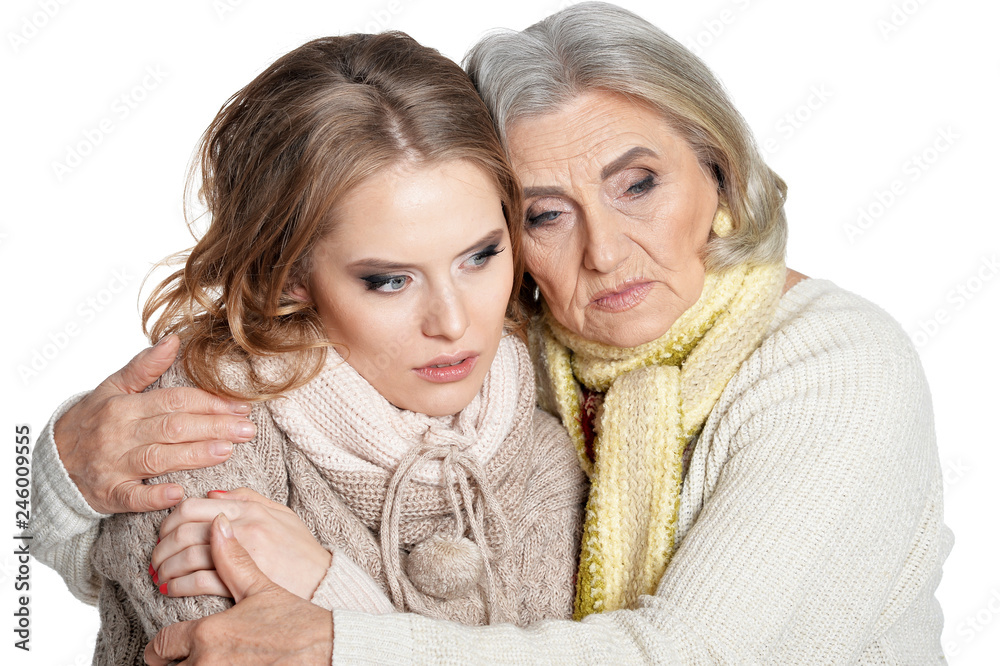 Sad senior woman with daughter on white background