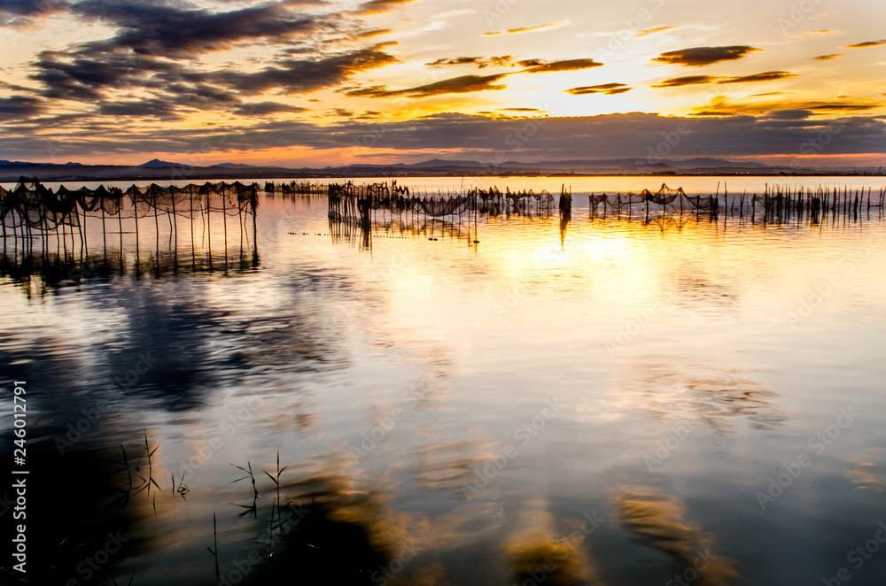 Beautiful orange sunset on one day cloudy in the famous lake of the albufera of Valencia, Spain.