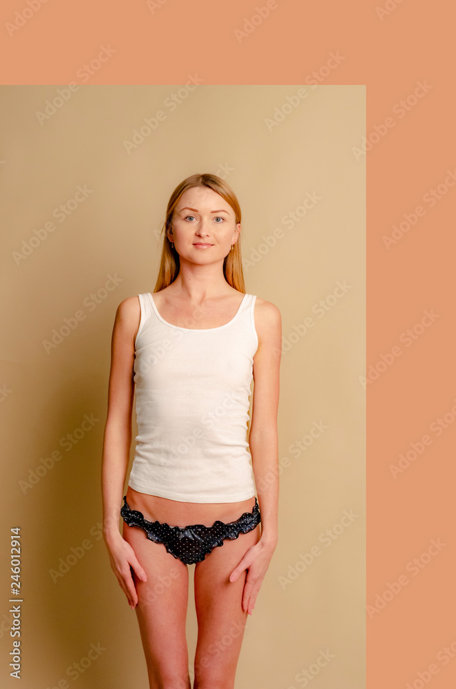 thin and young girl with long light hair dressed in a white T-shirt and  panties, with a beautiful figure and sexy poppies poses for a photo in the  studio Stock-foto
