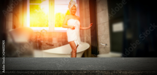 A wooden table and a girl in the bathroom with a beautiful sunset coming through the window  