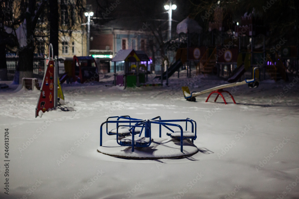 Children's carousel covered with snow in the park at night Children's carousel covered with snow in the park at night