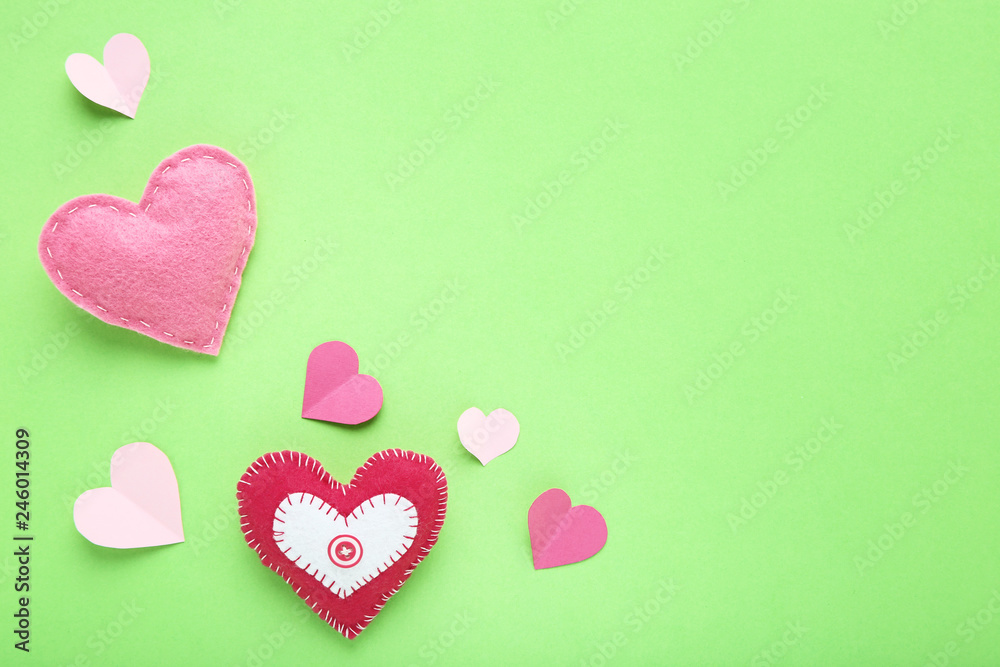 Fabric and paper hearts on green background