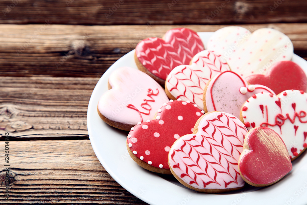 Valentine day heart shaped cookies in plate on brown wooden table - obrazy, fototapety, plakaty 