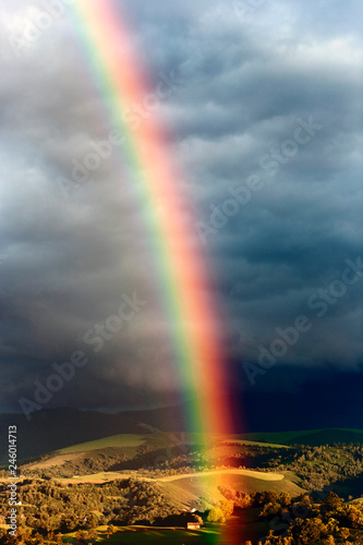 Breathtaking rainbow emerging in Southern France landscape - Pyrenees countryside near Lourdes © potstock