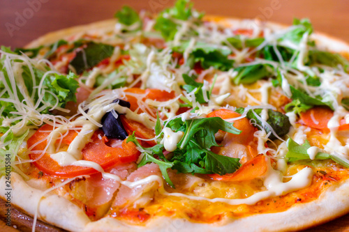 Hot tasty pizza with arugula, tomatoes and bacon