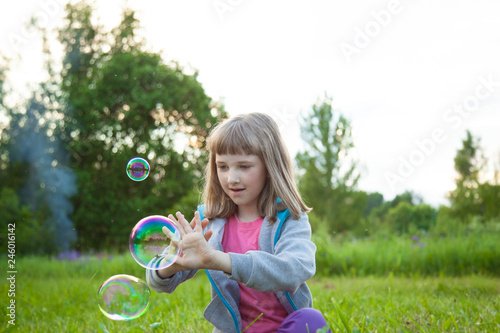 Adorable preschooler girl playing with soap bubbles