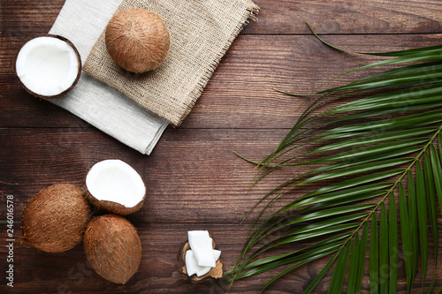 Ripe coconuts with palm leafs on brown wooden table
