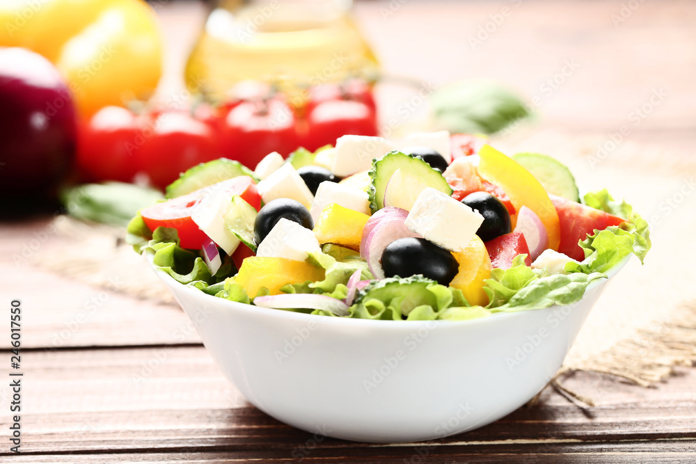 Vegetable salad in bowl on brown wooden table Vegetable salad in bowl on brown wooden table