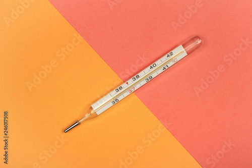 Medical mercury thermometer, Living Coral, trendy color 2019 background.  Free space for text.