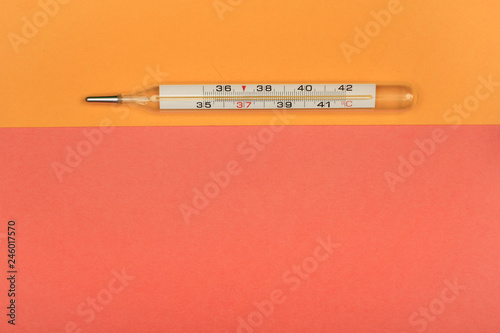 Medical mercury thermometer, Living Coral, trendy color 2019 background.  Free space for text.