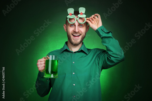 St. Patrick's Day. Young man wearing green glasses with beer © 5second