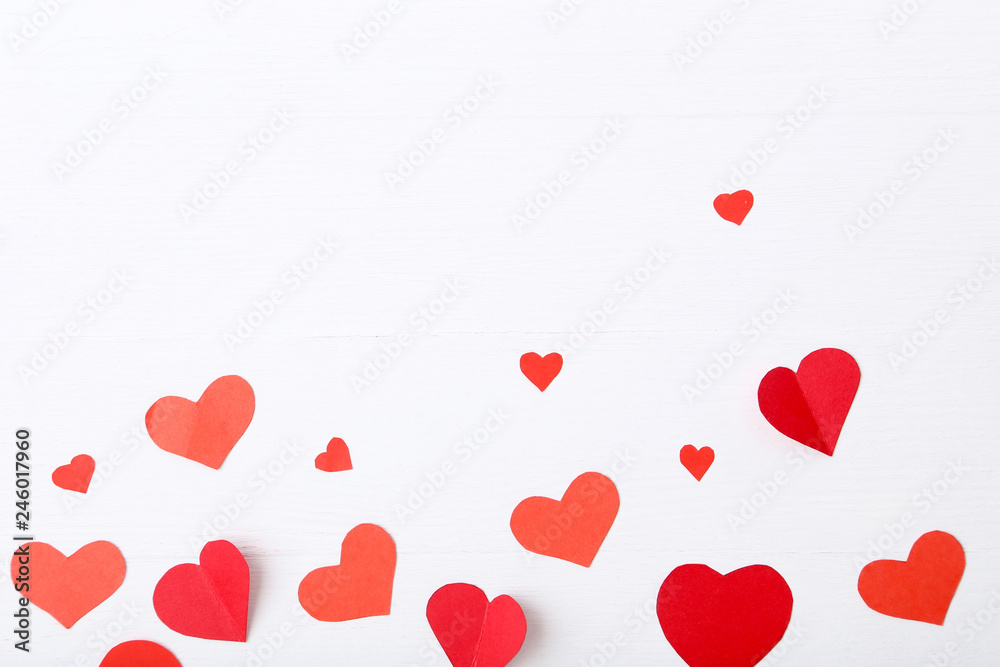 Red paper hearts on white wooden table
