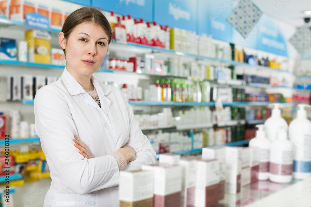 pharmacist standing with arms crossed in pharmacy