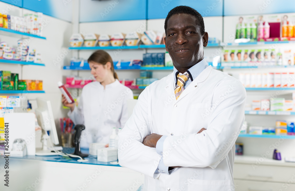 male pharmacist standing behind counter