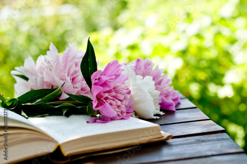 book, flowers and a cup of tea on a table in a spring garden, spring or summer card or calendar