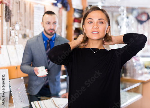 Female consumer trying chainlet with pendants photo