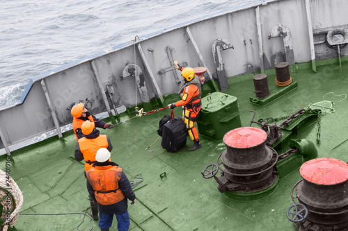 seamen carry out a rescue operation on the deck of a ship photo