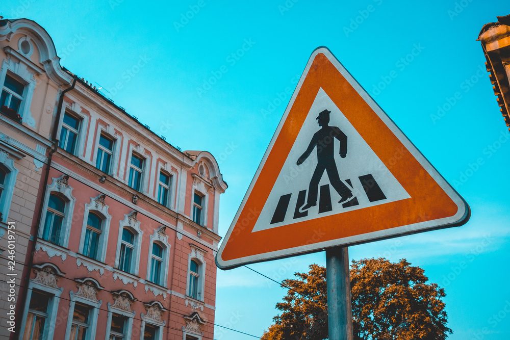 pedestrians crossing sign with red triangle lines