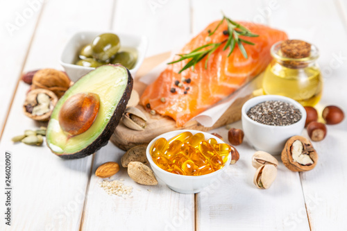 Selection of healthy unsaturated fats, omega 3 - fish, avocado, olives, nuts and seeds