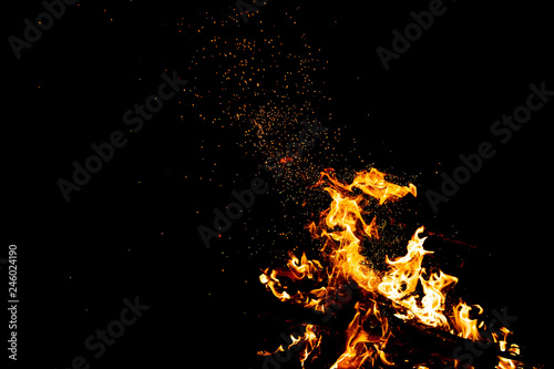 Burning woods with firesparks  flame and smoke. Strange weird odd elemental fiery figures on black background. Coal and ash. Abstract shapes at night. Bonfire outdoor on nature. Strenght of element.
