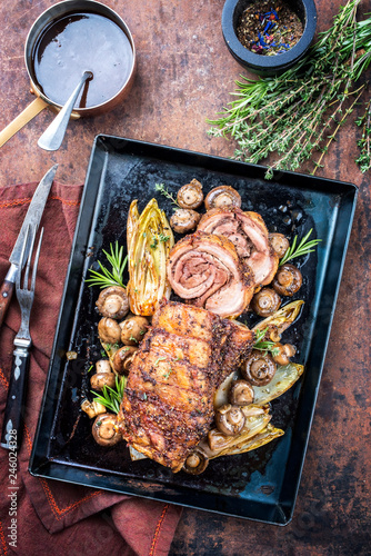 Tablou pe pânză Barbecue rolled boar roast with fried vegetable and mushroom as top view in a ba