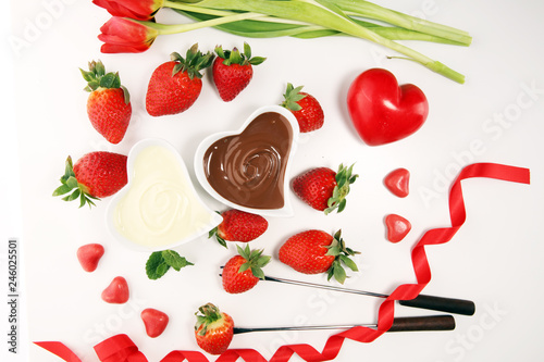 Valentine Chocolate fondue melted with fresh strawberries and dark and white chocolate. Tublips and sugar hearts. photo