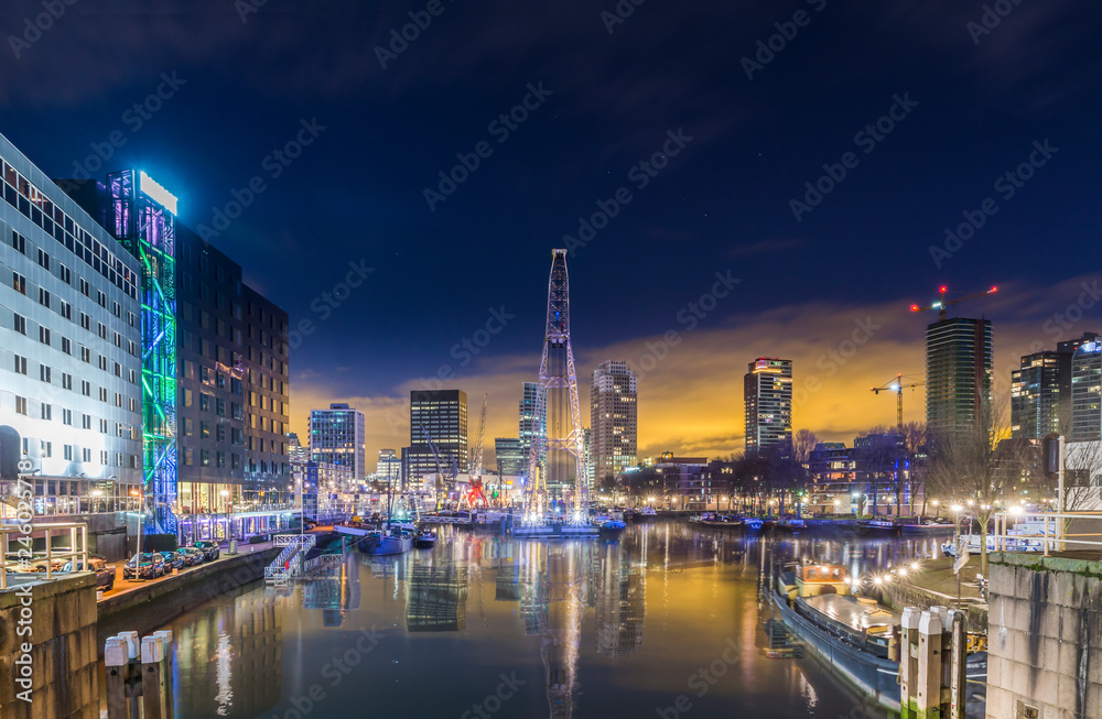 Obraz premium Harbor basin in Rotterdam before sunrise. Beautiful reflection of Rotterdam´s skyline in the harbor basin. Colorful cityscape