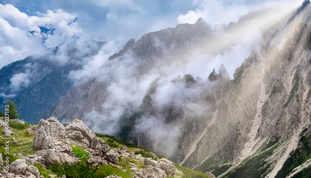 Mountain panorama in the Dolomite Alps, Italy. Mountain ridge in the clouds. Beautiful landscape at the summer time. Dolomite Alps, Italy-Image