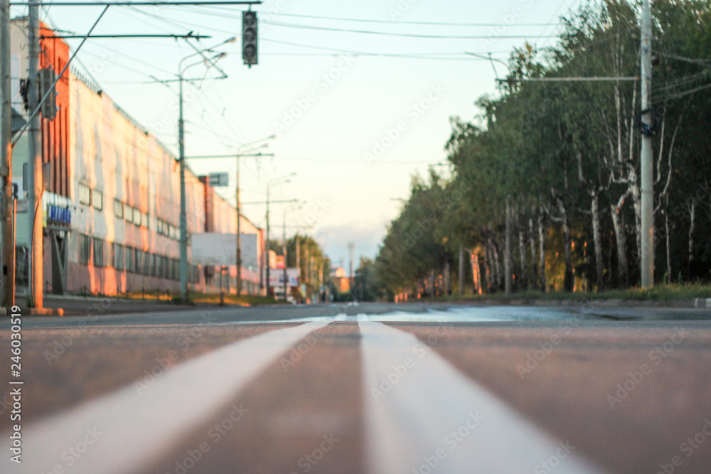 Photo of the road with a double solid strip with a small depth of field, blurred background and variable focus for wallpaper at sunrise