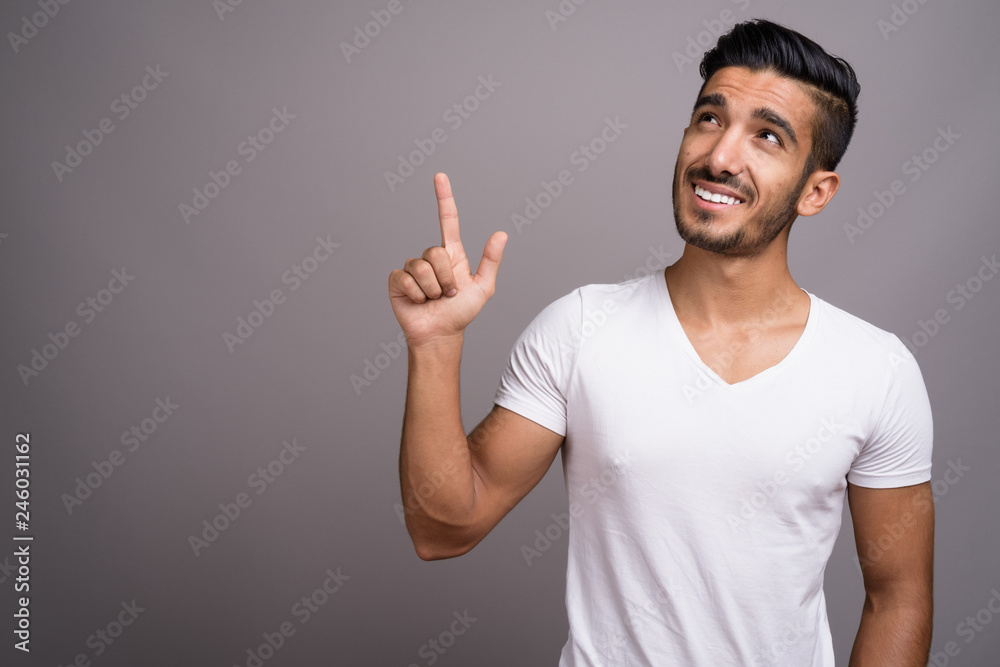 Young handsome Persian man against gray background Young handsome Persian man against gray background