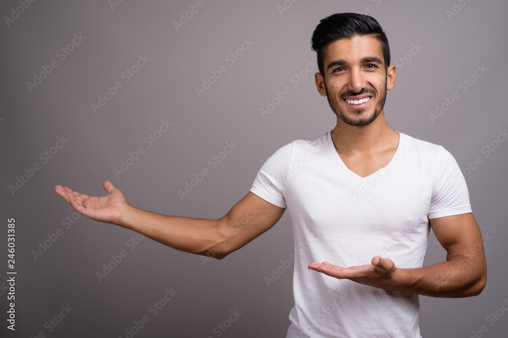 Young handsome Persian man against gray background Young handsome Persian man against gray background