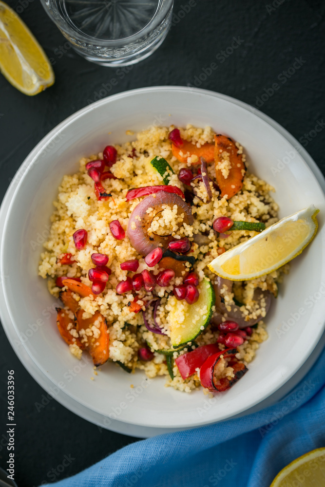Healthy vegetarian couscous with roasted vegetables on black background. close up. top view. vertical Healthy vegetarian couscous with roasted vegetables on black background. close up. top view. vertical