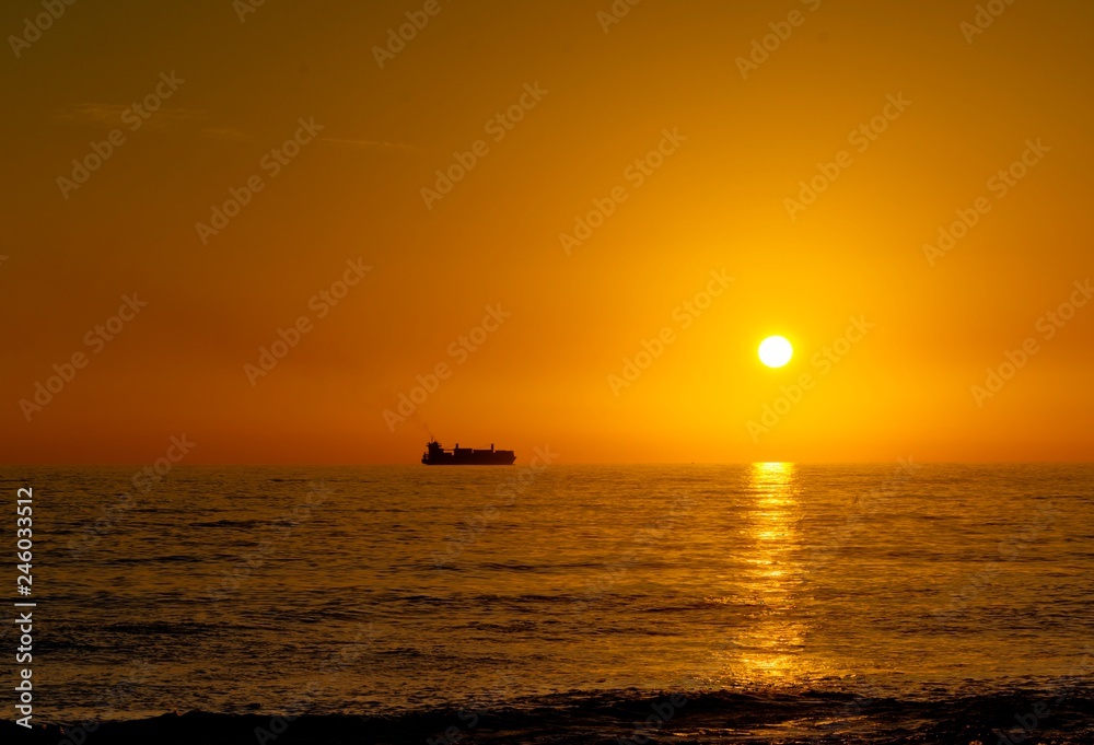 Nave mercantile in viaggio nel mare durante il tramonto 
