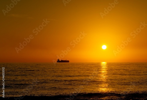 Nave mercantile in viaggio nel mare durante il tramonto 