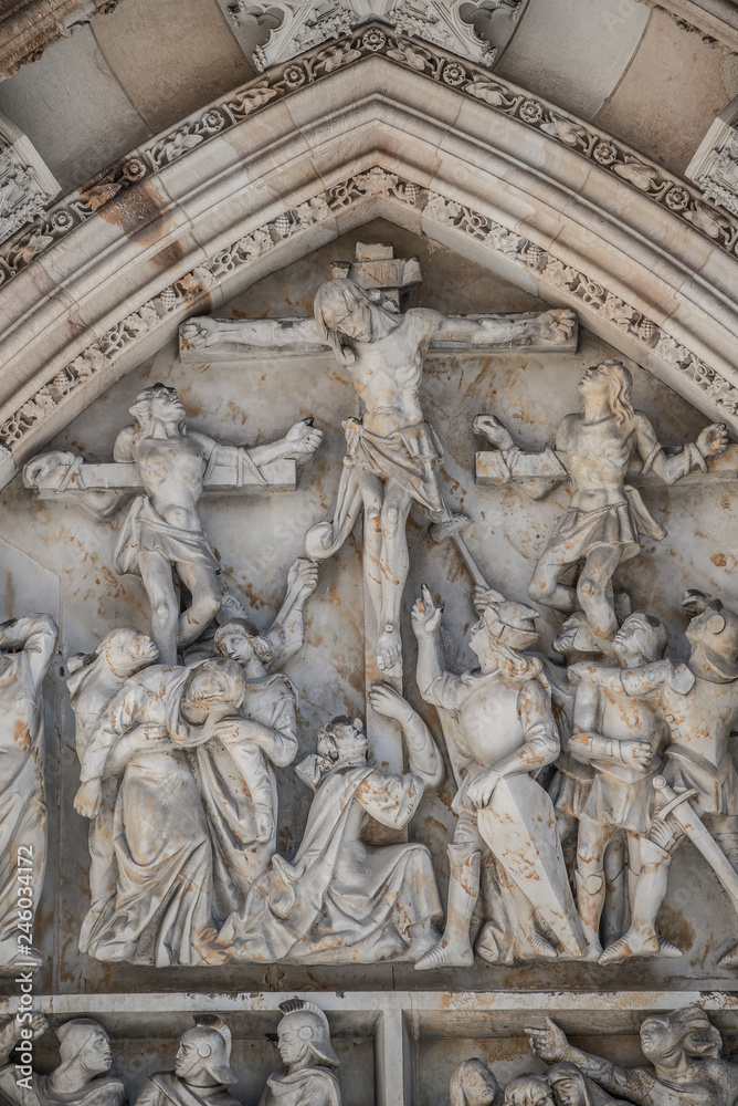 Crucifixion of Christ scene at major entrance portal of Saint Vitus Cathedral in Prague, Czech Republic, details, closeup