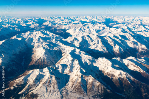 Swiss, Italy and Austrian Alps with snowy mountain tops aerial view towards the east during afternoon flight