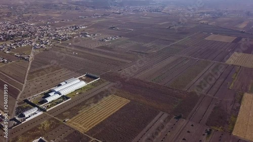 Upward aerial pan of town of Chalco, Mexico with volcano in distance photo