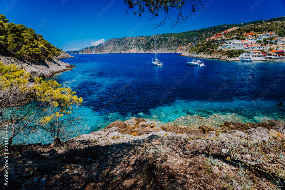 Amazing Greece, white sail boats in blue bay of picturesque colorful village Assos in Kefalonia