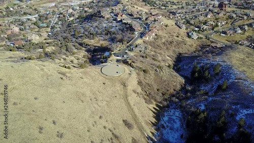 AERIAL: pushing and tilting away from the mountain terrain towards the small town and strange circular platform, within the Rocky Mountains in Colorado. photo