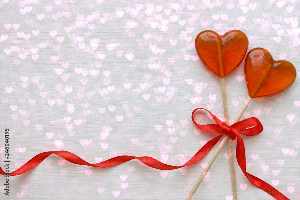 Romantic Valentine`s day background. Lollipops in the shape of heart close up isolated on white background. Copy space. Romantic Valentine`s day background. Lollipops in the shape of heart close up isolated on white background. Copy space.