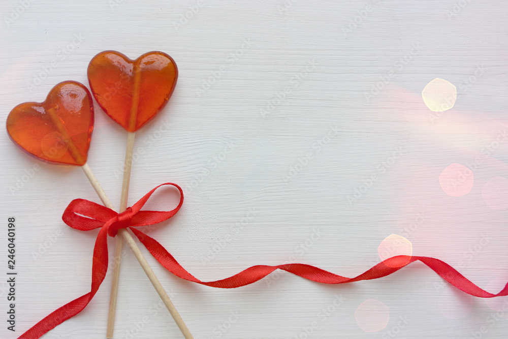 Romantic Valentine`s day background. Lollipops in the shape of heart close up isolated on white background. Copy space. Romantic Valentine`s day background. Lollipops in the shape of heart close up isolated on white background. Copy space.