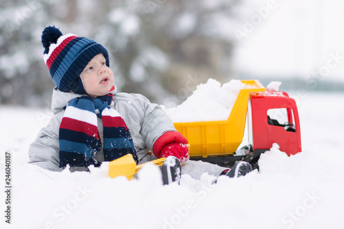little baby boy playing with his favourite toy at the snowtime photo