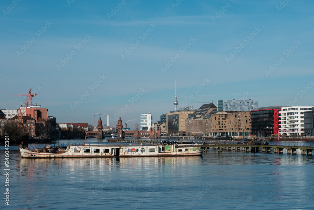 Berlin Skyline from river Spree with ship ruin, Oberbaum Bridge and TV Tower