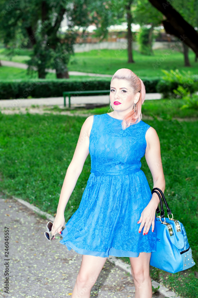 woman with a blue purse in a windy Park woman with a blue purse in a windy Park