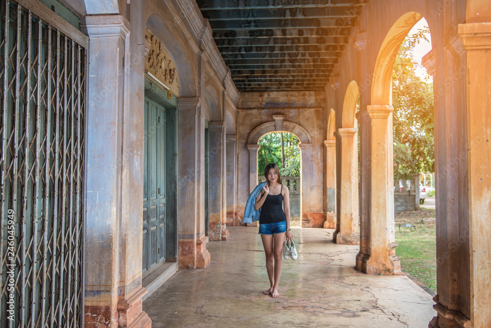 Beautiful Woman holding shoes walking in an abandoned building