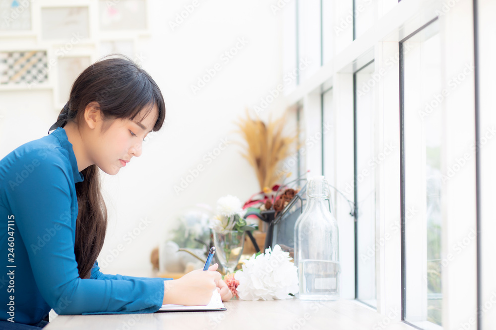 Beautiful portrait young asia woman writer writing on notebook or diary with happy, lifestyle of asian girl is student, female planning working, education and business concept. Beautiful portrait young asia woman writer writing on notebook or diary with happy, lifestyle of asian girl is student, female planning working, education and business concept.