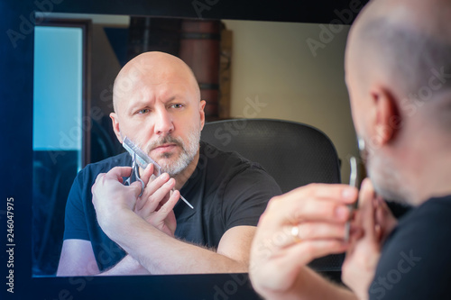 The man at the mirror is cu...