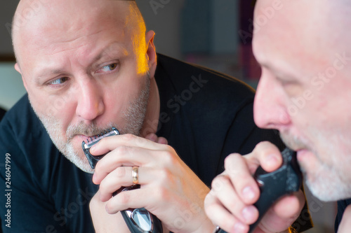 The man at the mirror is cu...