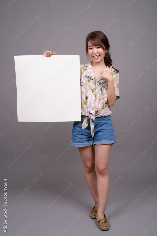 Asian woman holding empty white board with copyspace Asian woman holding empty white board with copyspace