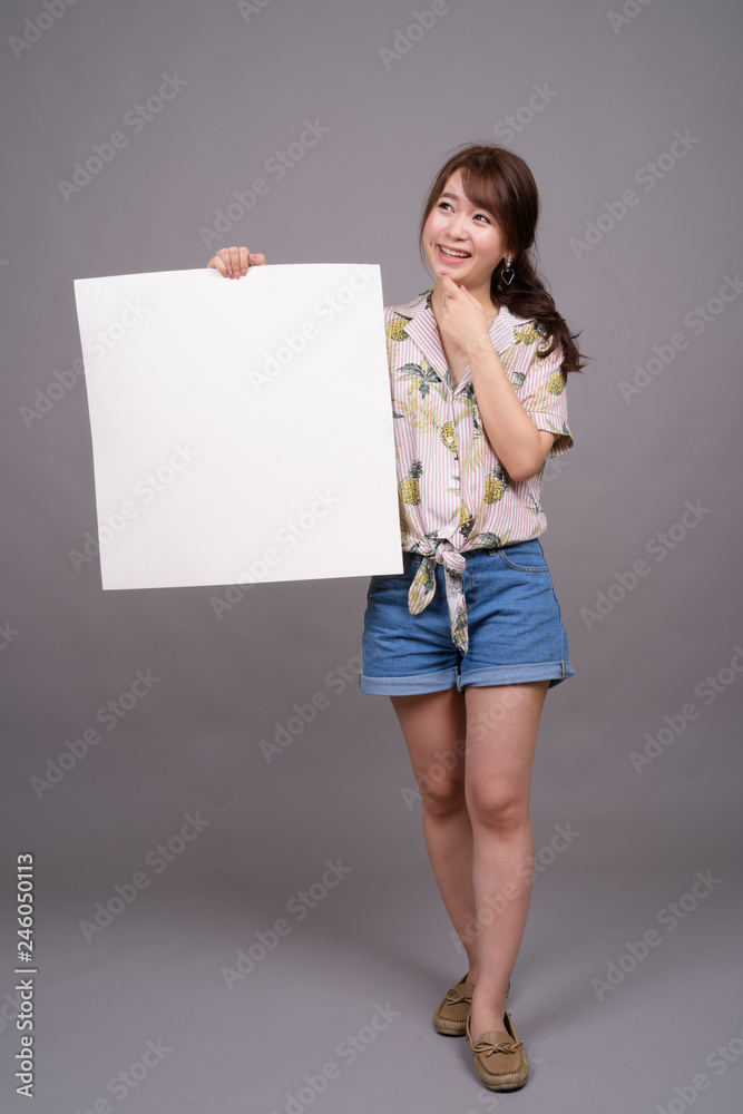 Asian woman holding empty white board with copyspace Asian woman holding empty white board with copyspace